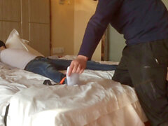 Minet asiatique se fait corder sur un lit d'hôtel par un ours